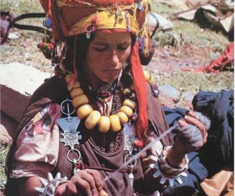 Berber woman from Morocco weaving a rug
